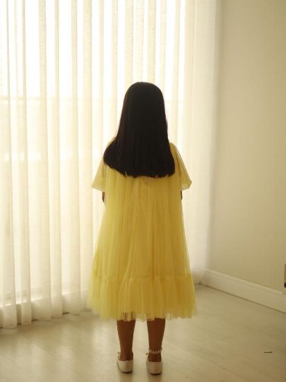 صورة فستان سهرة أصفر أنيق مزين بالؤلؤ على الصدر